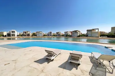a swimming pool with two chairs and a pair ofatoes at Luxury Stays in Tawila El Gouna in Hurghada