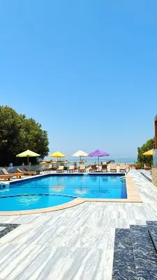a swimming pool with chairs and umbrellas and the ocean at Luxury apartment with beautiful view and free private beach in Hurghada