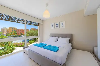 a bedroom with a bed and a large window at Special apartment with Pool and Seasideview, El Gouna in Hurghada