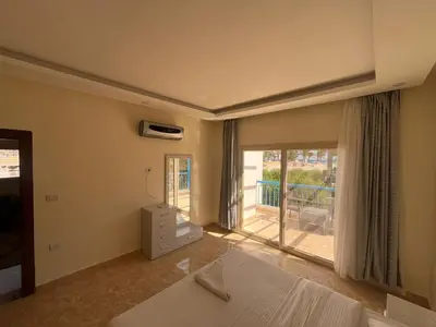 a bedroom with a bed and a balcony at شاليه بقرية ميراج باي in Hurghada