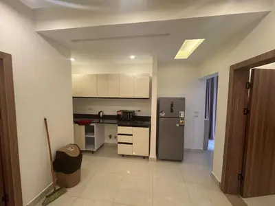 a kitchen with a stainless steel refrigerator and white cabinets at شاليه بقرية ميراج باي in Hurghada