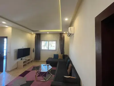 a living room with a couch and a tv at شاليه بقرية ميراج باي in Hurghada