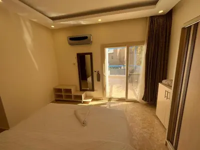 a bedroom with a bed and a sliding glass door at شاليه بقرية ميراج باي in Hurghada