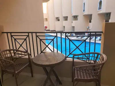 a balcony with two chairs and a swimming pool at جوليانا بيتش ريزورت in Hurghada