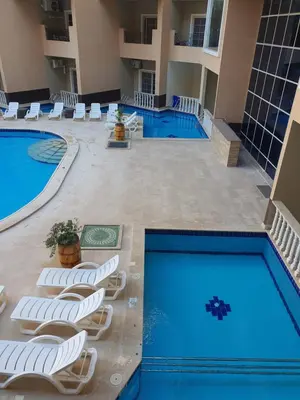 a pool with lounge chairs and two swimming pools at جوليانا بيتش ريزورت in Hurghada