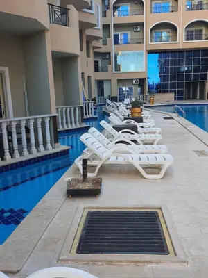 a row of white lounge chairs next to a swimming pool at جوليانا بيتش ريزورت in Hurghada