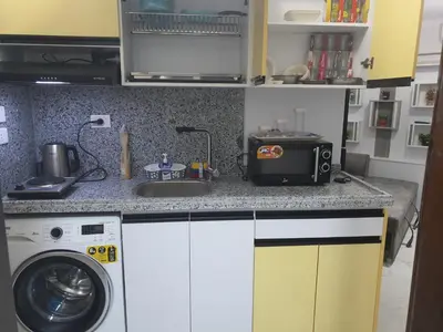 a kitchen with a sink and a washing machine at جوليانا بيتش ريزورت in Hurghada
