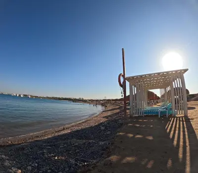 a bench on the shore of a beach at Avenuo apartment in Hurghada