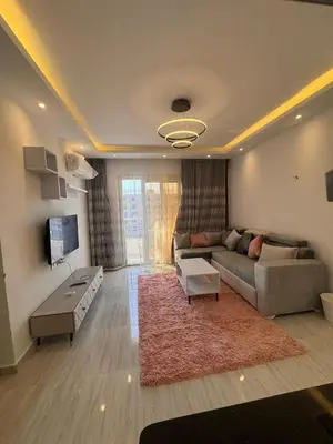 a living room with a couch and a tv at Avenuo apartment in Hurghada