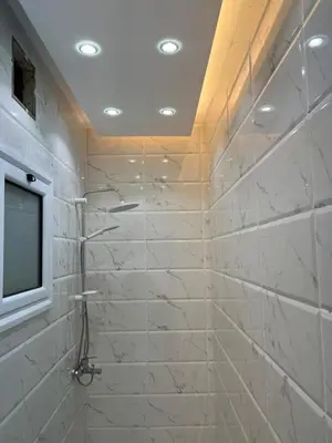 a bathroom with a shower with a television on the wall at Royal view suite in Hurghada
