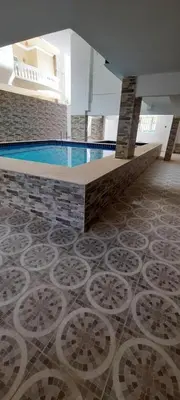 a swimming pool in a building with a tile floor at Royal view suite in Hurghada