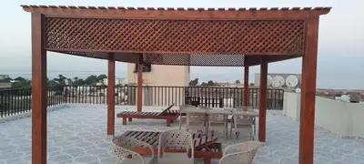 a pavilion with chairs and a bench on a balcony at Royal view suite in Hurghada