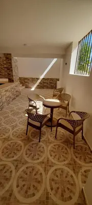 a room with chairs and a table and a table and benches at Royal view suite in Hurghada