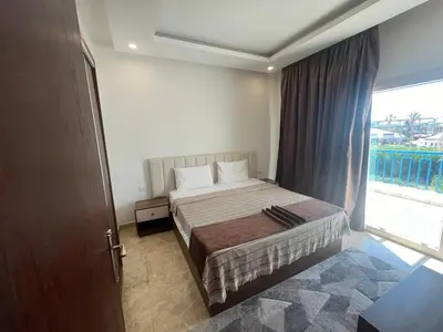 a bedroom with a bed and a large window at شاليه ميراج باي ريزورت in Hurghada