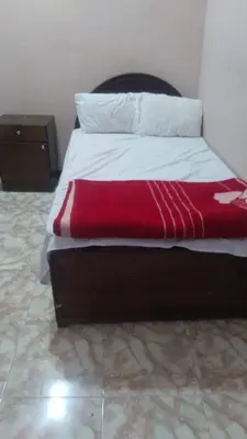 a bed with a red blanket on top of it at The Nile apartment in Luxor