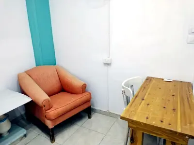 a brown chair sitting next to a wooden table at room 3 a room in Hostel of 4 rooms in Hurghada
