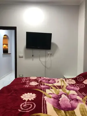 a bedroom with a bed with a tv on the wall at sheraton street in Hurghada