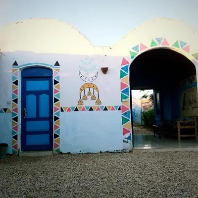 a building with a blue door and a mural on it at Kody doll in Jazīrat Suhayl
