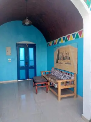 a room with a bench and a blue wall at Kody doll in Jazīrat Suhayl