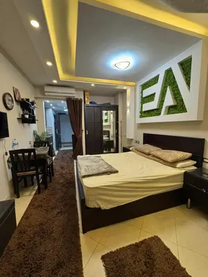a bedroom with a large bed and a dining room at كمباوند فلورينزا خمسين وسط الغردقه in Hurghada