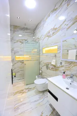 a bathroom with a toilet and a sink and a mirror at Jeanie's House in Al Karnak