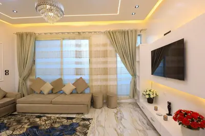 a living room with a couch and a tv at Jeanie's House in Al Karnak
