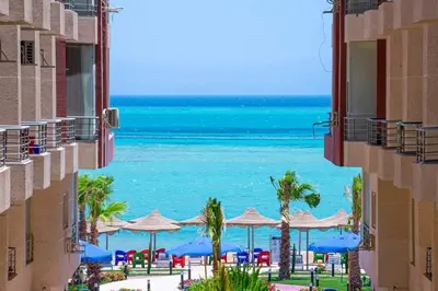 a view of the beach from between two buildings at كذابلانكا بيتش in Hurghada