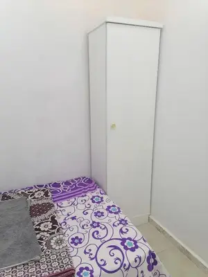 a bedroom with a bed and a white cabinet at room1 a room in Hostel of 4 rooms in Hurghada