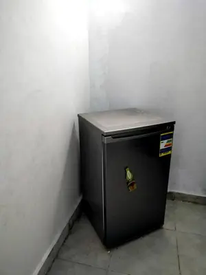 a small black refrigerator in a corner of a wall at room1 a room in Hostel of 4 rooms in Hurghada