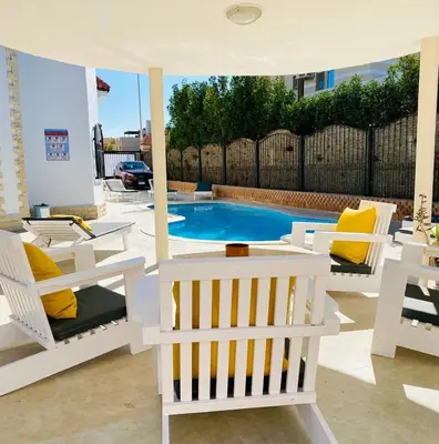 a patio with chairs and a swimming pool at Magawish Hurghada Apartement 1 in Hurghada