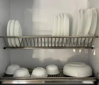 a shelf with white plates and bowls in a kitchen at Bayt Hassan S19 - Super spacious roof top One Bedroom apartment in Hurghada