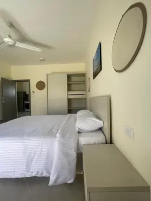 a bedroom with a white bed and a table at Bayt Hassan S19 - Super spacious roof top One Bedroom apartment in Hurghada