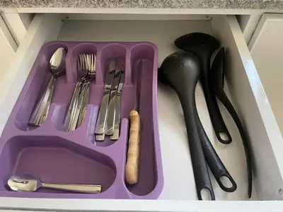 a purple tray with utensils in a drawer at Bayt Hassan S19 - Super spacious roof top One Bedroom apartment in Hurghada