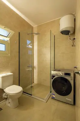 a bathroom with a washing machine and a toilet at Bayt Hassan A3 - 2 bedrooms European style Apartment in Hurghada