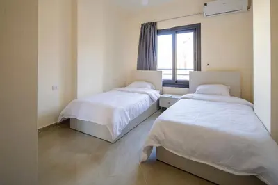 two beds in a room with a window at Bayt Hassan A3 - 2 bedrooms European style Apartment in Hurghada