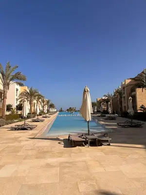 a beach with umbrellas and chairs and a swimming pool at studio in El Gouna-mangroovy , Egypt in Hurghada