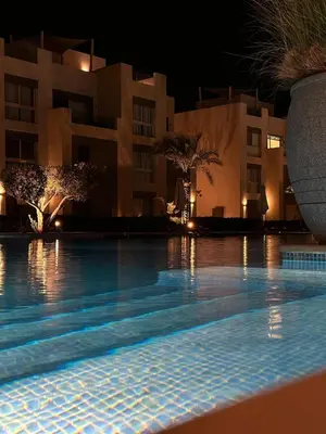 a swimming pool in front of a building at night at studio in El Gouna-mangroovy , Egypt in Hurghada