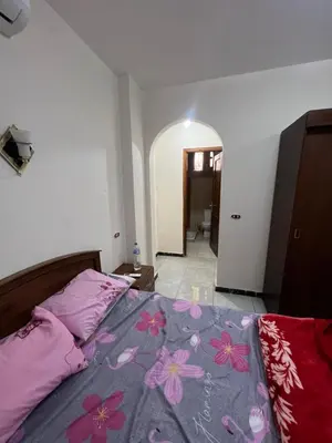 a bedroom with a bed with pink flowers on it at 3 bedroom duplex in Hurghada