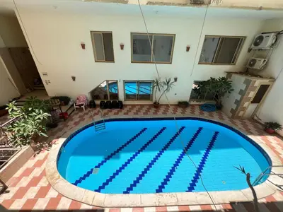 a large blue swimming pool in the middle of a building at 3 bedroom duplex in Hurghada