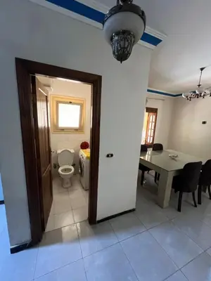 a room with a toilet and a dining room with a table at 3 bedroom duplex in Hurghada