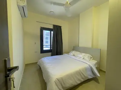 a bedroom with a white bed and a window at Bayt Hassan A12 - 2 bedrooms European new apartment in Hurghada
