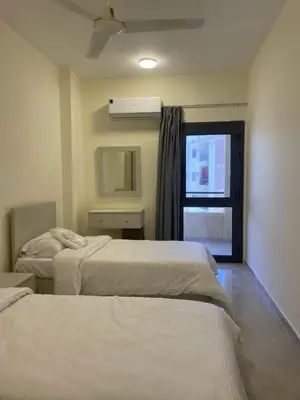 a hotel room with two beds and a window at Bayt Hassan A12 - 2 bedrooms European new apartment in Hurghada