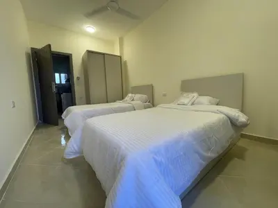 two beds in a room with white sheets at Bayt Hassan A12 - 2 bedrooms European new apartment in Hurghada