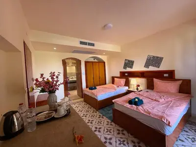 a bedroom with two beds with pink sheets at Nile Compound Garden in Al Aqālitah