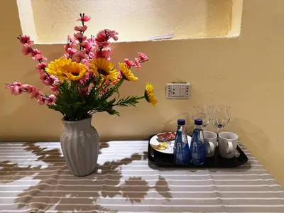 a vase of flowers sitting on a table with drinks at Nile Compound Garden in Al Aqālitah