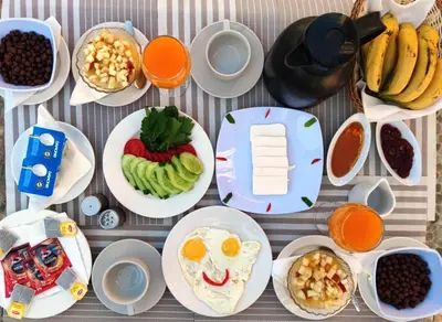 a table topped with plates of food and fruit at Nile Compound Garden in Al Aqālitah