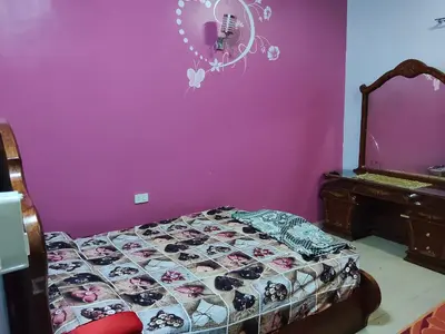 a bedroom with a bed and a purple wall at Hamza home in Quseir