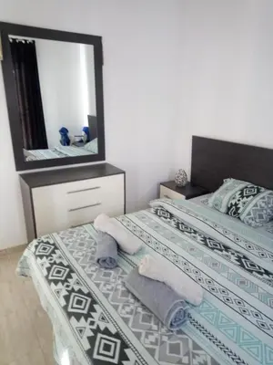 a bedroom with two beds with towels and a mirror at Cozy one bedroom apartment in AquaPalms resort in Hurghada