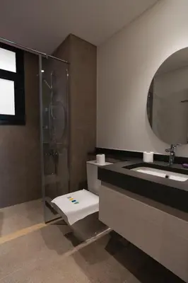 a bathroom with a shower and a toilet and a sink at Serene 1BR Haven Kamaran in Hurghada