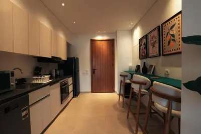 a kitchen with a bar and some stools in it at Serene 1BR Haven Kamaran in Hurghada